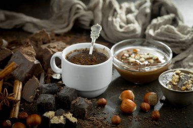 Eskimiş bir arka planda kakao çekirdeği ve fındıklı siyah çikolata..