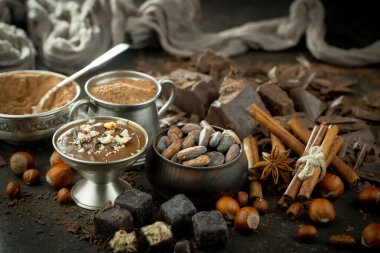 Eskimiş bir arka planda kakao çekirdeği ve fındıklı siyah çikolata..