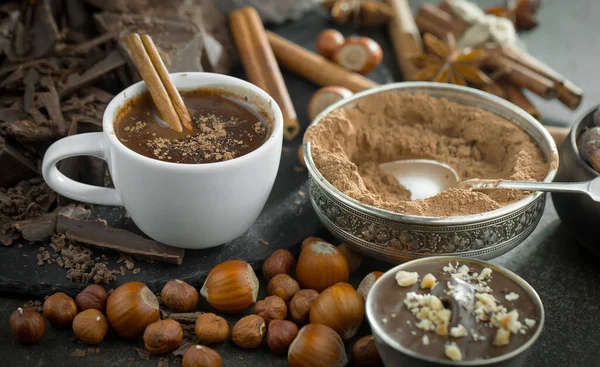 Eskimiş bir arka planda kakao çekirdeği ve fındıklı siyah çikolata..