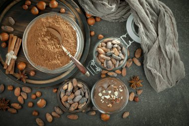 Eskimiş bir arka planda kakao çekirdeği ve fındıklı siyah çikolata..