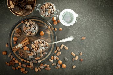 Eskimiş bir arka planda kakao çekirdeği ve fındıklı siyah çikolata..