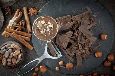 Eskimiş bir arka planda kakao çekirdeği ve fındıklı siyah çikolata..