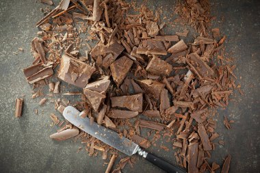 Eskimiş bir arka planda kakao çekirdeği ve fındıklı siyah çikolata..