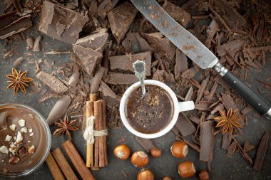 Eskimiş bir arka planda kakao çekirdeği ve fındıklı siyah çikolata..