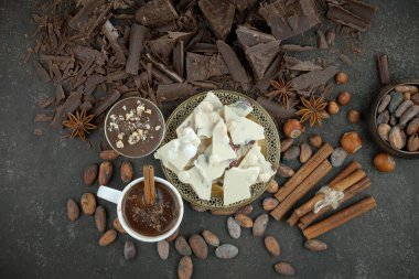 Eskimiş bir arka planda kakao çekirdeği ve fındıklı siyah çikolata..