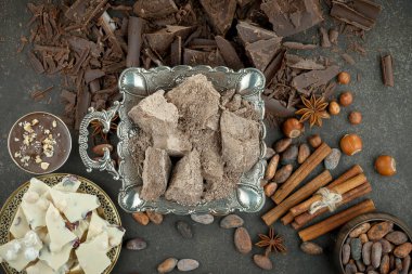 Eskimiş bir arka planda kakao çekirdeği ve fındıklı siyah çikolata..