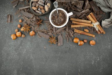 Eskimiş bir arka planda kakao çekirdeği ve fındıklı siyah çikolata..