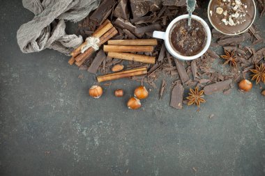 Eskimiş bir arka planda kakao çekirdeği ve fındıklı siyah çikolata..