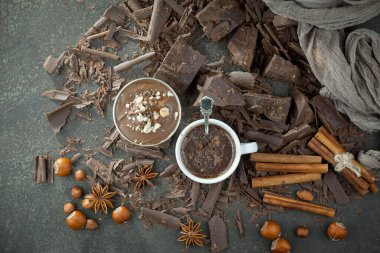 Eskimiş bir arka planda kakao çekirdeği ve fındıklı siyah çikolata..