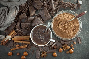 Eskimiş bir arka planda kakao çekirdeği ve fındıklı siyah çikolata..