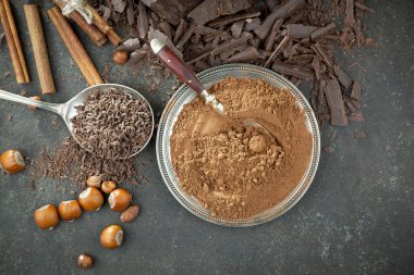 Eskimiş bir arka planda kakao çekirdeği ve fındıklı siyah çikolata..