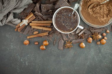 Eskimiş bir arka planda kakao çekirdeği ve fındıklı siyah çikolata..