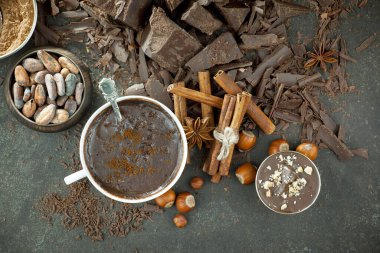 Eskimiş bir arka planda kakao çekirdeği ve fındıklı siyah çikolata..