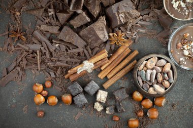 Eskimiş bir arka planda kakao çekirdeği ve fındıklı siyah çikolata..