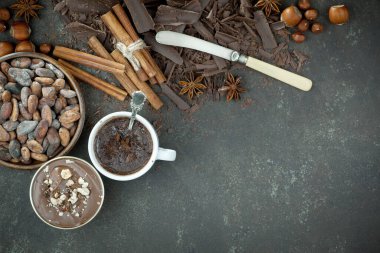 Eskimiş bir arka planda kakao çekirdeği ve fındıklı siyah çikolata..