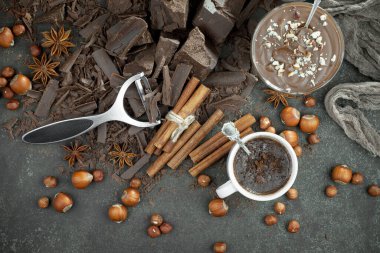 Eskimiş bir arka planda kakao çekirdeği ve fındıklı siyah çikolata..