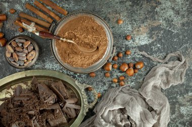 Eskimiş bir arka planda kakao çekirdeği ve fındıklı siyah çikolata..