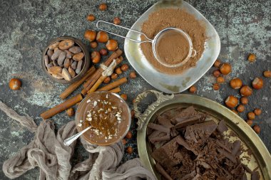 Eskimiş bir arka planda kakao çekirdeği ve fındıklı siyah çikolata..