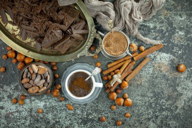 Eskimiş bir arka planda kakao çekirdeği ve fındıklı siyah çikolata..