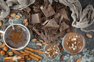 Eskimiş bir arka planda kakao çekirdeği ve fındıklı siyah çikolata..