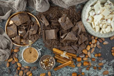 Eskimiş bir arka planda kakao çekirdeği ve fındıklı siyah çikolata..