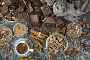 Eskimiş bir arka planda kakao çekirdeği ve fındıklı siyah çikolata..