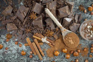 Eskimiş bir arka planda kakao çekirdeği ve fındıklı siyah çikolata..