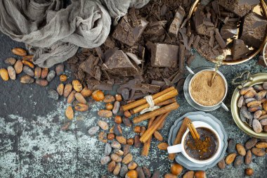 Eskimiş bir arka planda kakao çekirdeği ve fındıklı siyah çikolata..