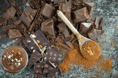 Eskimiş bir arka planda kakao çekirdeği ve fındıklı siyah çikolata..