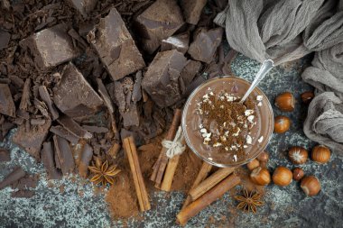 Eskimiş bir arka planda kakao çekirdeği ve fındıklı siyah çikolata..