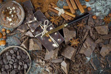 Eskimiş bir arka planda kakao çekirdeği ve fındıklı siyah çikolata..