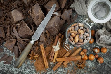Eskimiş bir arka planda kakao çekirdeği ve fındıklı siyah çikolata..