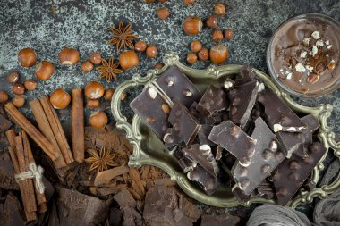 Eskimiş bir arka planda kakao çekirdeği ve fındıklı siyah çikolata..
