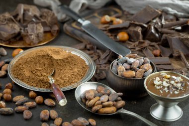 Eskimiş bir arka planda kakao çekirdeği ve fındıklı siyah çikolata..