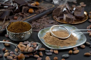 Eskimiş bir arka planda kakao çekirdeği ve fındıklı siyah çikolata..