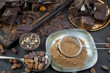 Eskimiş bir arka planda kakao çekirdeği ve fındıklı siyah çikolata..