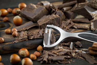 Eskimiş bir arka planda kakao çekirdeği ve fındıklı siyah çikolata..