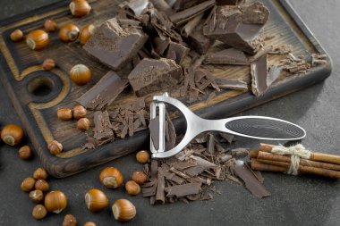 Eskimiş bir arka planda kakao çekirdeği ve fındıklı siyah çikolata..