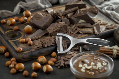 Eskimiş bir arka planda kakao çekirdeği ve fındıklı siyah çikolata..