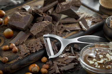 Eskimiş bir arka planda kakao çekirdeği ve fındıklı siyah çikolata..