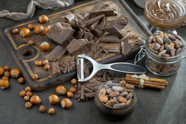 Eskimiş bir arka planda kakao çekirdeği ve fındıklı siyah çikolata..