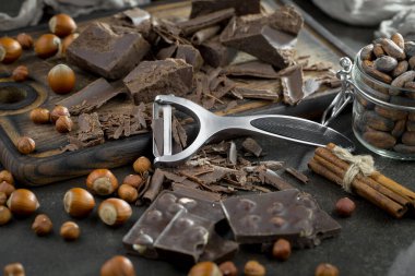 Eskimiş bir arka planda kakao çekirdeği ve fındıklı siyah çikolata..