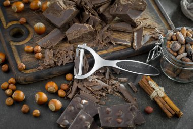 Eskimiş bir arka planda kakao çekirdeği ve fındıklı siyah çikolata..