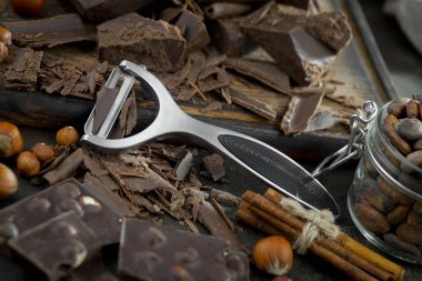 Eskimiş bir arka planda kakao çekirdeği ve fındıklı siyah çikolata..