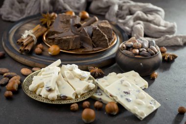 Eskimiş bir arka planda kakao çekirdeği ve fındıklı siyah çikolata..