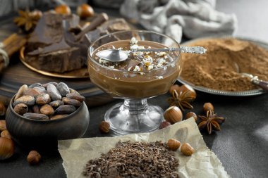 Eskimiş bir arka planda kakao çekirdeği ve fındıklı siyah çikolata..