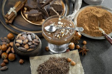 Eskimiş bir arka planda kakao çekirdeği ve fındıklı siyah çikolata..