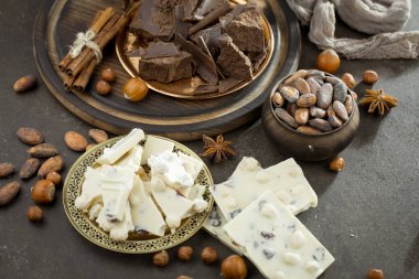 Eskimiş bir arka planda kakao çekirdeği ve fındıklı siyah çikolata..