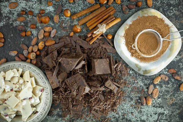 Eskimiş bir arka planda kakao çekirdeği ve fındıklı siyah çikolata..