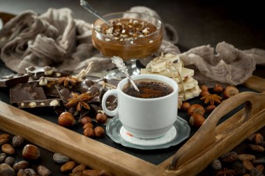 Eskimiş bir arka planda kakao çekirdeği ve fındıklı siyah çikolata..